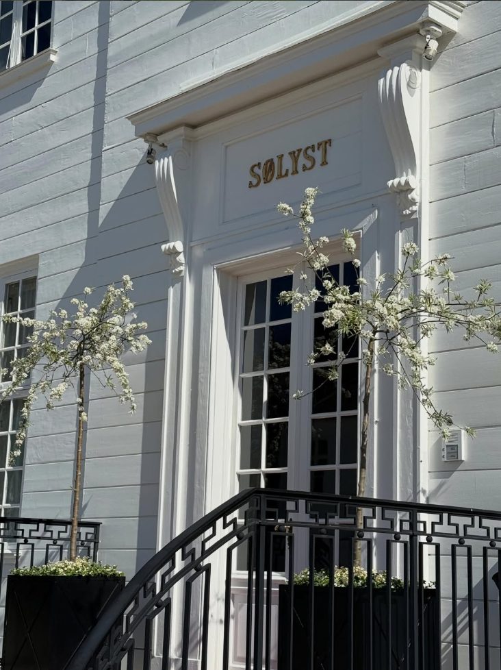 The entrance to Sølyst with gilded lettering and blossoming trees